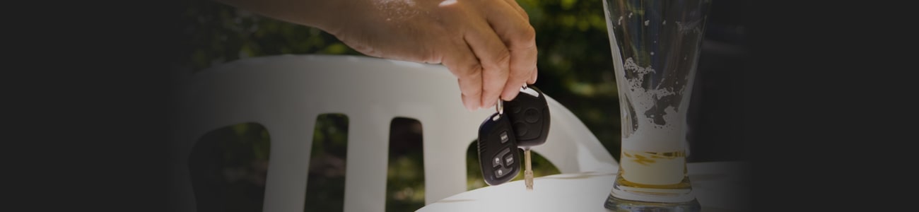 Banner picture of hand with car keys and empty beer glass next to it