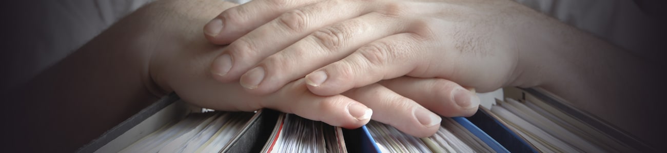 Banner picture of hands over a set of books